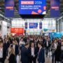 Thousands of digital marketing professionals exploring expo stands and networking at DMEXCO 2026 inside the Koelnmesse exhibition halls in Cologne, Germany